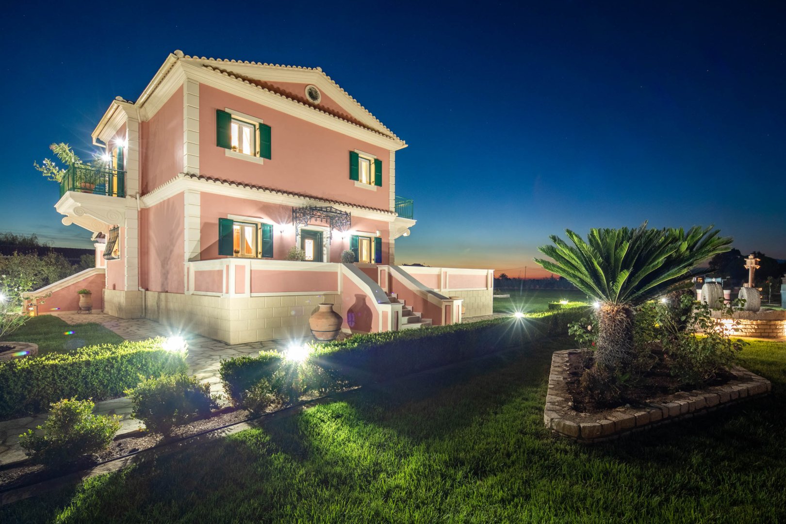 Villa illuminated at dusk with garden lighting